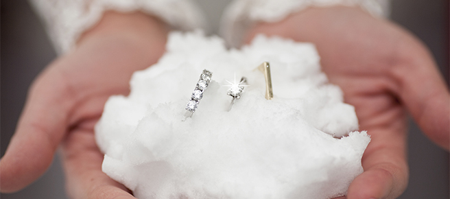 手の上に作られた雪のリングピローと婚約指輪