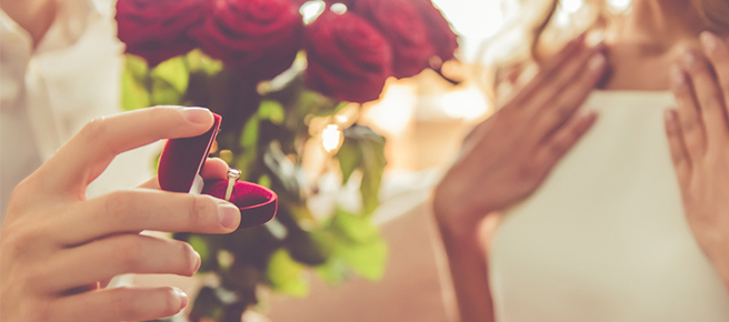 プロポーズで赤いバラと婚約指輪をプレゼントする男性